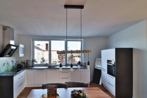een keuken met witte kasten en een groot raam bij Air Apartments 14 in Bremen
