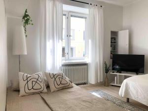 a white living room with a bed and a window at Modern and Bright Studio with Top Location in Helsinki