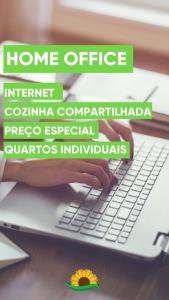 una persona sta scrivendo su un computer portatile di Pousada Girassois Hostel a Florianópolis