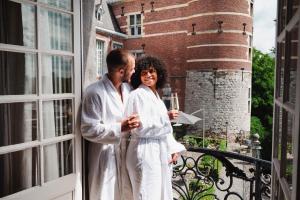 mężczyzna i kobieta stojący na balkonie w obiekcie Van Der Valk Sélys Liège Hotel & Spa w mieście Liège