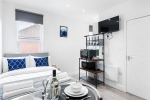 a white bedroom with a bed and a table at Modern Studio Rooms in Zone 2 London in London