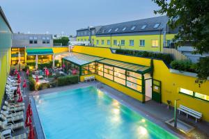 an overhead view of a swimming pool in front of a building at Vienna Sporthotel in Vienna