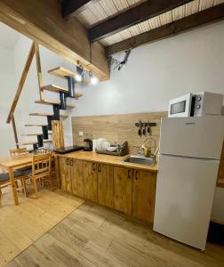 a kitchen with a refrigerator and a staircase at Nafta Aparts & Villas in Skhidnitsa