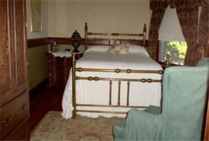 um quarto com uma cama e uma cadeira em Fleetwood House Bed and Breakfast em Portland