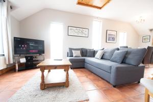 a living room with a couch and a tv at 3 Fishery Cottages - 2 Bedroom house close to town in Bundoran