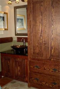 a bathroom with a wooden cabinet next to a sink at Fleetwood House Bed and Breakfast in Portland