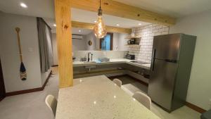 a kitchen with a refrigerator and a table with chairs at Loft novo em Morro de São Paulo in Morro de São Paulo +11 photos