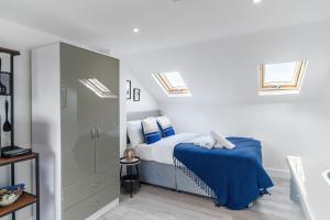 um quarto com uma cama com lençóis azuis e clarabóias em Modern Studio Rooms in Zone 2 London em Londres