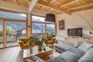 a living room with a couch and a large window at Chalet 124 in Chamonix