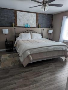 a bedroom with a large bed with a ceiling fan at Suite in the Bush-Private Apartment in Bancroft