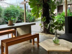 a room with benches and a table with a vase at Mad about Coco Yoga & Beach Retreat in Varkala