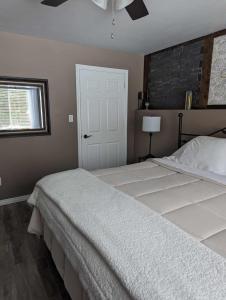 a bedroom with a large white bed and a window at Suite in the Bush-Private Apartment in Bancroft