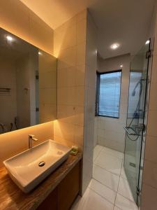 uma casa de banho com um lavatório e uma cabina de duche em vidro. em VIP penthouse with swimming pool and panoramic view em Kuala Lumpur