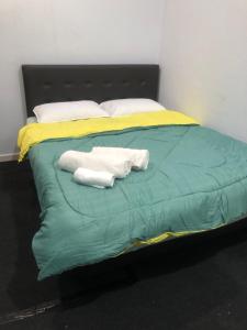 Una cama con dos toallas encima. en A & Z Roomstay, en Pasir Mas
