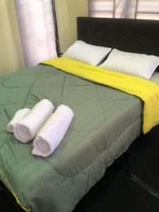 Una cama con dos toallas enrolladas. en A & Z Roomstay, en Pasir Mas