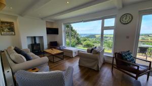 sala de estar con reloj y ventana grande en Tantallon, en Saint Just in Roseland