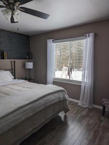 a bedroom with a bed and a large window at Suite in the Bush-Private Apartment in Bancroft