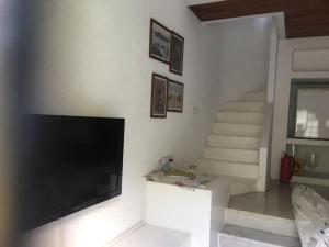 a living room with a flat screen tv and stairs at Castle81homes Blue - Sea view house in Marmaris
