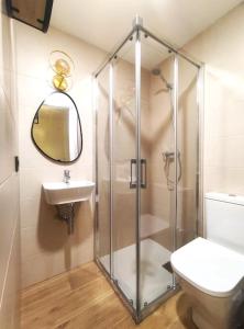 a bathroom with a shower and a toilet and a sink at Oasis Suites Fernando IV in Seville