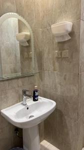 y baño con lavabo blanco y espejo. en استيديو بالعقيق بدخول ذاتي c3, en Riad