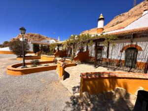 un patio de un edificio con bancos y luz de la calle en Cuevas La Granja, en Benalúa de Guadix