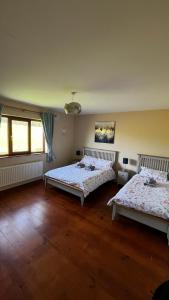 Habitación grande con 2 camas y suelo de madera. en BARR AN CHNOIC HOLIDAY LETTINGS en Tipperary