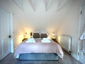 a bedroom with a large bed with towels on it at Converted coach house with parking in Pittenweem in Pittenweem