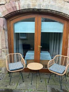 three chairs and a table in front of a door at Converted coach house with parking in Pittenweem in Pittenweem