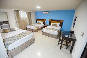 Habitación de hotel con 2 camas y pared azul en Metro Hotel Panama, en Panamá