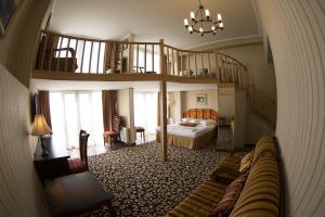 a living room with a bed and a spiral staircase at Shirak Hotel in Yerevan