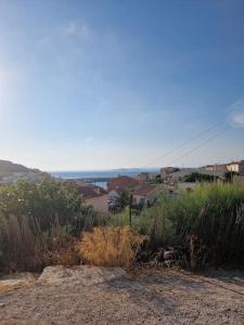 a view of a city from a hill with tall grass at Charmante maison familiale vue sur mer in Marseille