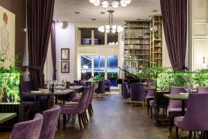a dining room with tables and purple chairs at Modern Art Hotel - Maestro in Lviv