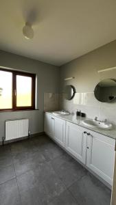 a bathroom with two sinks and two mirrors at BARR AN CHNOIC HOLIDAY LETTINGS in Tipperary