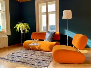 uma sala de estar com cadeiras laranja e uma parede azul em Ferienwohnung La Scala em Trin