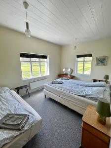 1 dormitorio con 2 camas y 2 ventanas en Syðri-Þverá en Hvammstangi