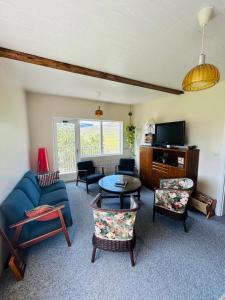 a living room with a blue couch and chairs at Syðri-Þverá in Hvammstangi