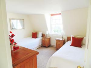 1 dormitorio con 2 camas y 2 ventanas en 18 The Circus Apartment en Bath