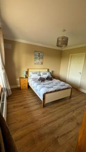 a bedroom with a bed and a wooden floor at BARR AN CHNOIC HOLIDAY LETTINGS in Tipperary