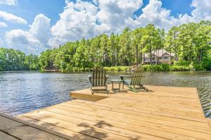 three chairs and a table on a dock on a lake at Sleeps 10 Whispering Pines 