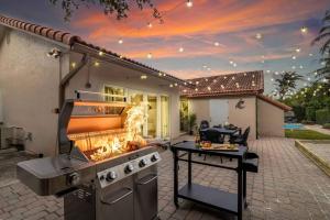 a barbecue grill in a backyard of a house at Villa, Beach, Pool, Spa, Games in Cutler Bay