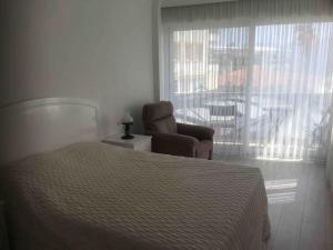a bedroom with a bed and a chair and a window at Castle81homes Red, sea view central flat in Marmaris