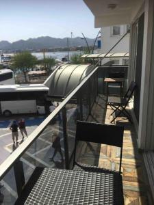 a balcony with a chair and people walking on a building at Castle81homes Red, sea view central flat in Marmaris