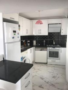 a kitchen with white appliances and a black counter top at Castle81homes Red, sea view central flat in Marmaris