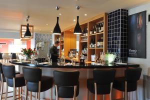 a bar in a restaurant with black stools at The Brudenell in Aldeburgh