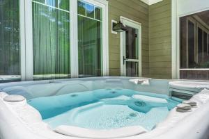 a jacuzzi tub in the backyard of a house at Sleeps 10 Whispering Pines 