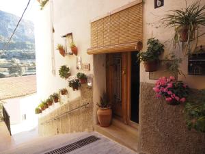 an entrance to a building with potted plants and a door at Ca iaia Rosario - Casa rural con catas premiadas, obrador y senderismo in Cuatretondeta