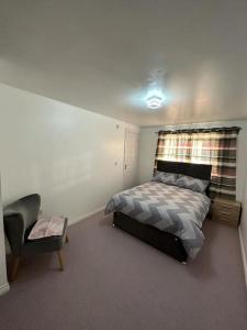 a bedroom with a bed and a chair in it at Spacious & Lovely 4 Bedroom Home in Manchester in Manchester