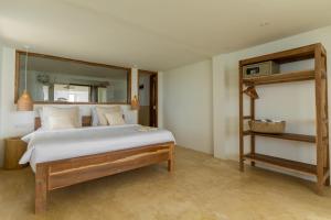 ein Schlafzimmer mit einem großen Bett und einem Spiegel in der Unterkunft Blue Waves Surf Hotel Sri Lanka in Ahangama