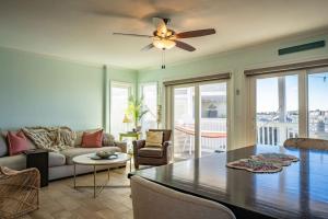 sala de estar con ventilador de techo y mesa en Waterfront Condo Carolina Beach en Carolina Beach