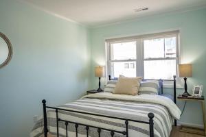 1 dormitorio con 1 cama con 2 lámparas y una ventana en Waterfront Condo Carolina Beach en Carolina Beach